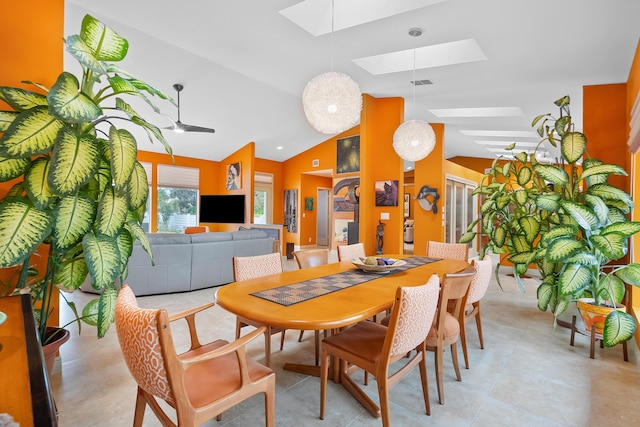 dining space featuring ceiling fan and vaulted ceiling with skylight