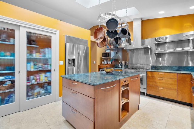 kitchen featuring tasteful backsplash, dark stone countertops, range hood, a kitchen island, and appliances with stainless steel finishes