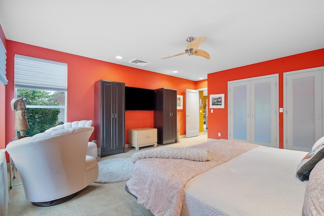 bedroom with ceiling fan and two closets