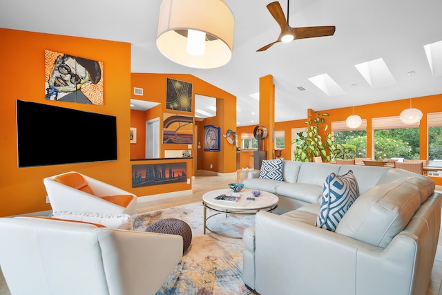 living room featuring ceiling fan and vaulted ceiling with skylight