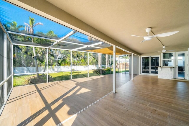 unfurnished sunroom featuring ceiling fan