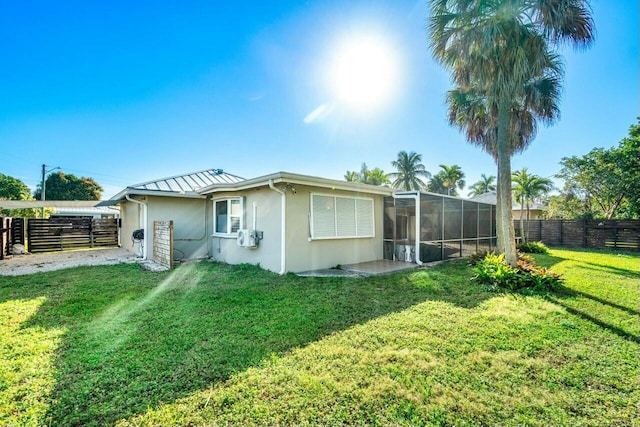 back of property featuring a yard and a sunroom