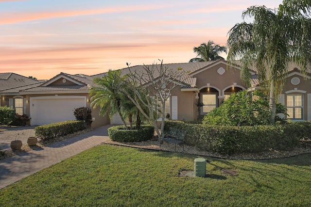 view of front of home with a yard and a garage