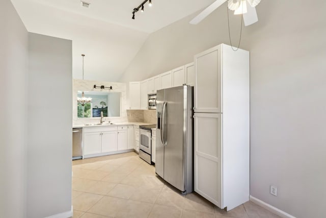 kitchen featuring light tile patterned floors, white cabinetry, appliances with stainless steel finishes, ceiling fan with notable chandelier, and sink