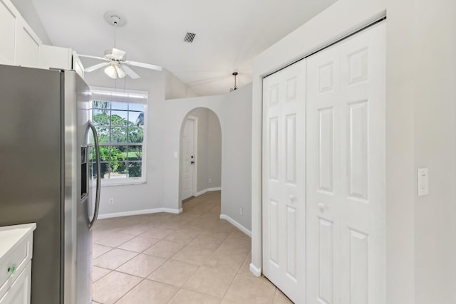 kitchen with ceiling fan, light tile patterned floors, stainless steel refrigerator with ice dispenser, and white cabinetry