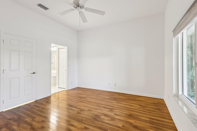 empty room featuring ceiling fan, dark hardwood / wood-style flooring, and plenty of natural light