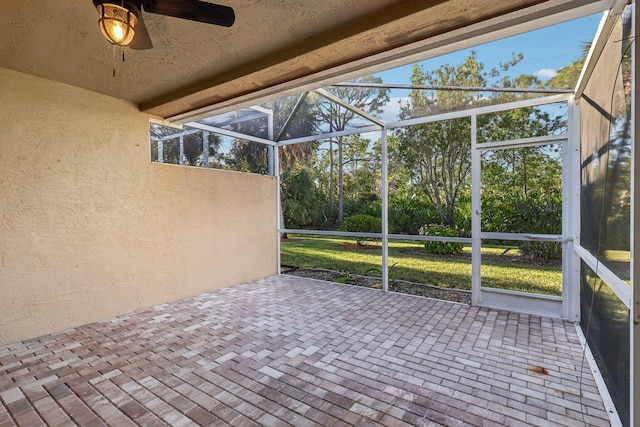 unfurnished sunroom featuring ceiling fan