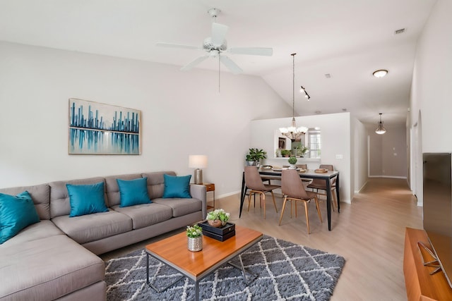 living room with hardwood / wood-style floors, lofted ceiling, and ceiling fan with notable chandelier