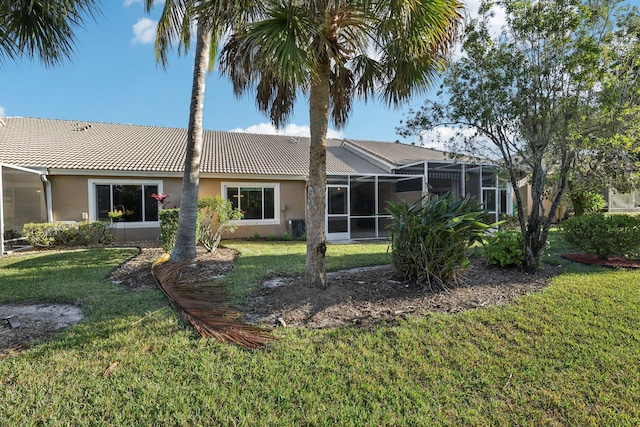 back of property featuring a lanai and a yard