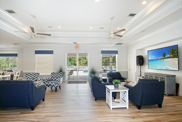 living room featuring ceiling fan, crown molding, and a tray ceiling