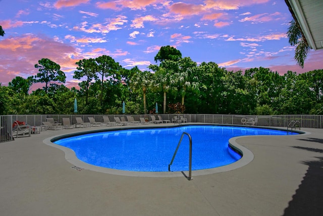 pool at dusk with a patio