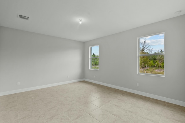 tiled empty room featuring a healthy amount of sunlight