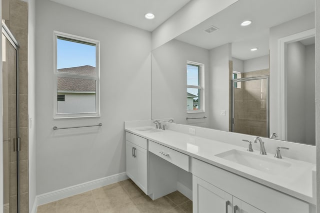 bathroom featuring tile patterned flooring, vanity, a shower with door, and a healthy amount of sunlight