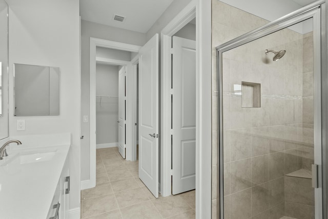 bathroom with tile patterned flooring, vanity, and an enclosed shower