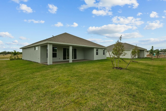 rear view of house with a lawn and a patio