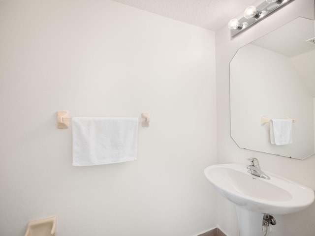 bathroom with a textured ceiling and sink