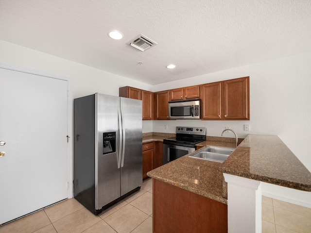 kitchen featuring kitchen peninsula, sink, light tile patterned floors, and stainless steel appliances