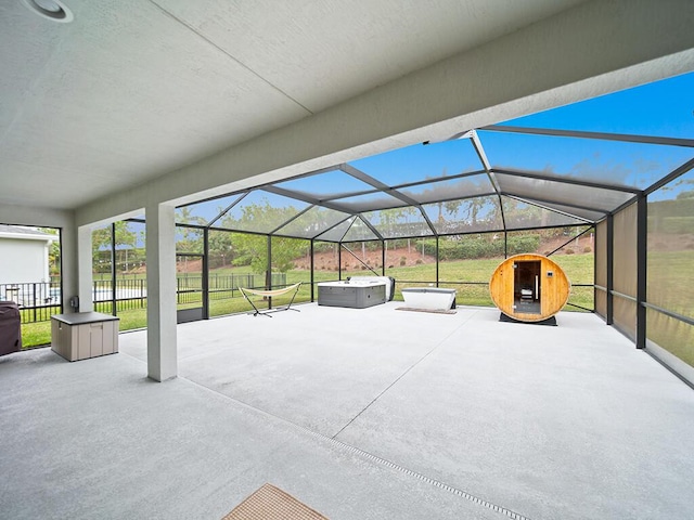 view of patio / terrace with a lanai and a hot tub