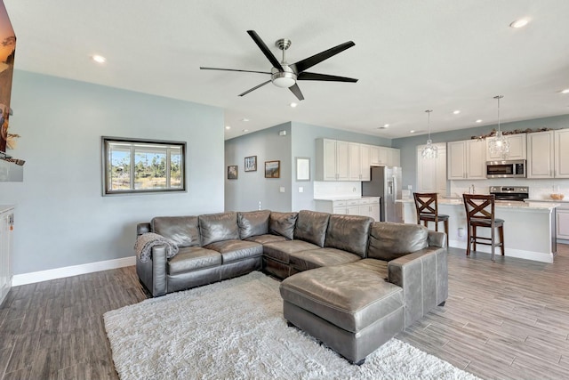 living room featuring ceiling fan and light wood-type flooring