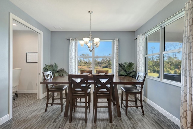 dining room featuring plenty of natural light, dark hardwood / wood-style floors, and an inviting chandelier