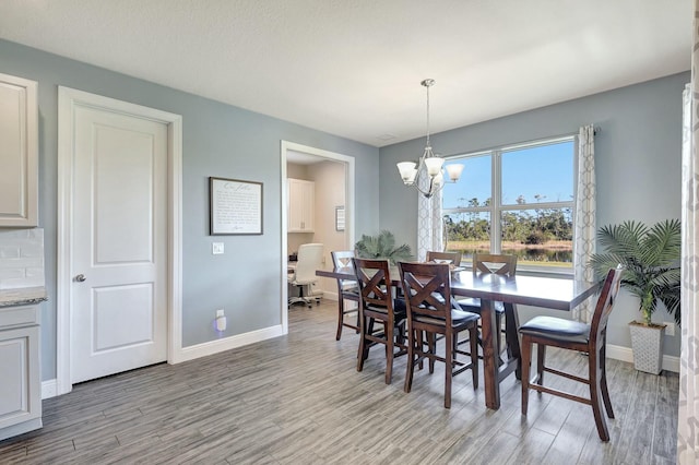 dining space with a notable chandelier and light wood-type flooring