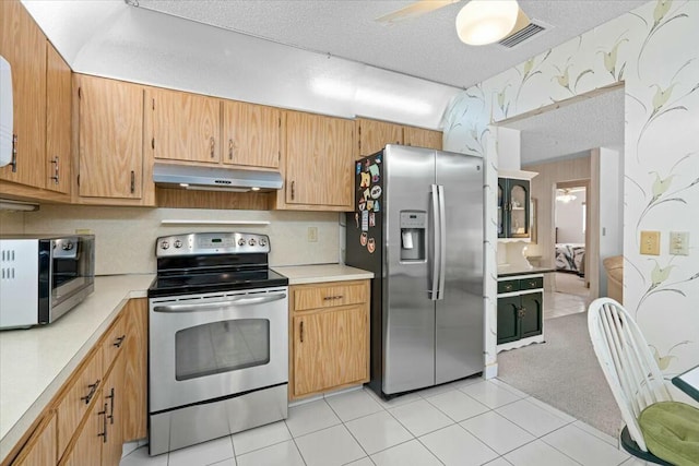 kitchen with ceiling fan, light tile patterned floors, a textured ceiling, and appliances with stainless steel finishes