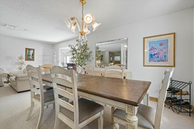 dining room featuring light colored carpet, a textured ceiling, and a chandelier