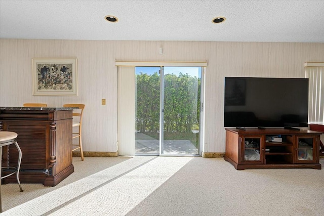 carpeted living room featuring a textured ceiling