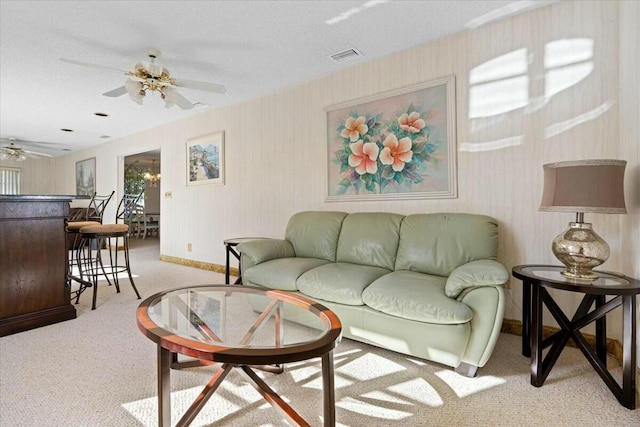 carpeted living room with a textured ceiling and ceiling fan