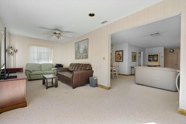 carpeted living room with a textured ceiling and ceiling fan