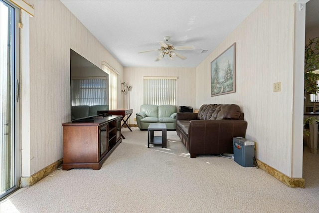 carpeted living room with ceiling fan