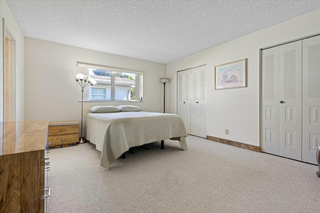 bedroom featuring a textured ceiling and two closets