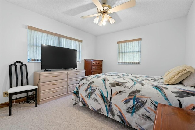 carpeted bedroom with ceiling fan and a textured ceiling