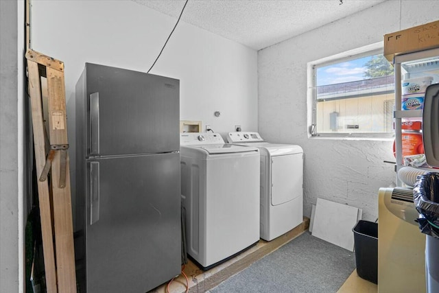 laundry area with washer and dryer and a textured ceiling