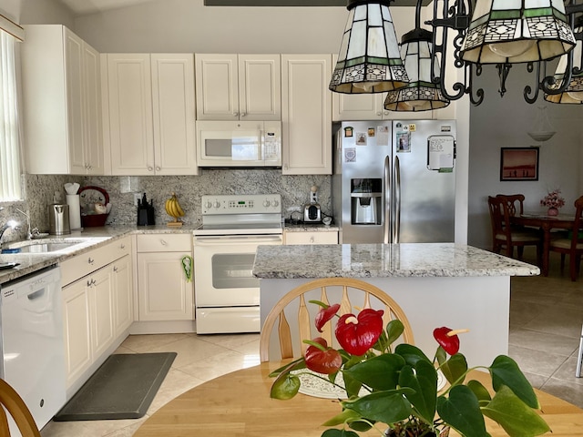 kitchen with light tile patterned flooring, white appliances, white cabinetry, and light stone countertops