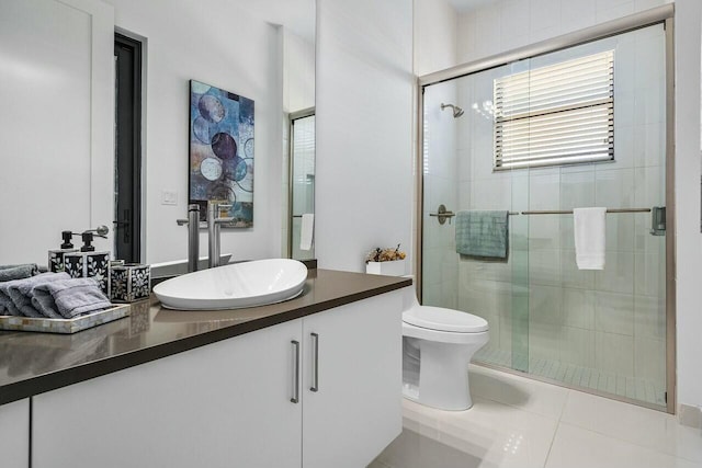 bathroom featuring tile patterned flooring, vanity, and a shower with door