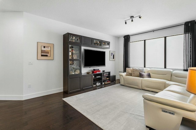 living room with a textured ceiling and dark wood-type flooring