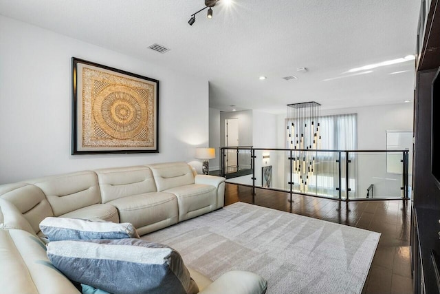 living room featuring a textured ceiling and dark wood-type flooring