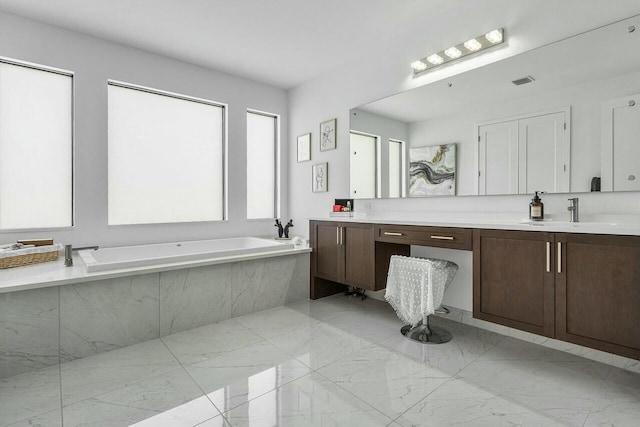 bathroom with vanity and a relaxing tiled tub