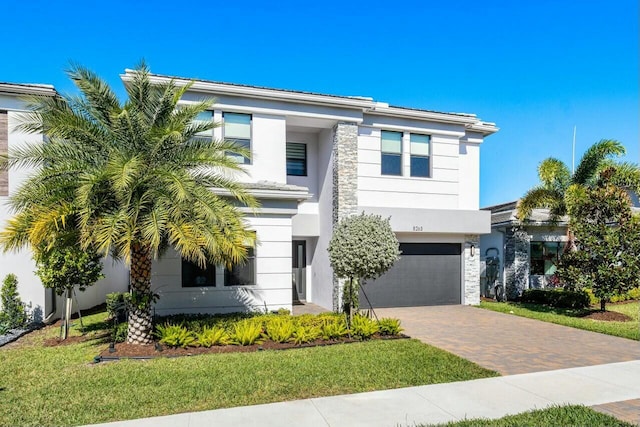 view of front of home with a front yard and a garage