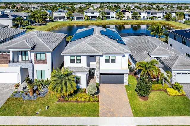 view of front of house with a water view, a garage, and solar panels