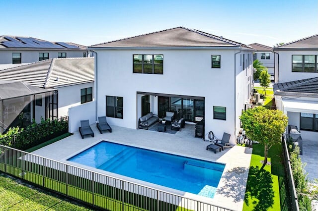 rear view of property with an outdoor hangout area and a fenced in pool