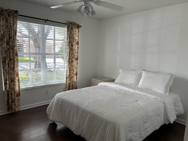 bedroom featuring a textured ceiling, ceiling fan, and dark hardwood / wood-style flooring