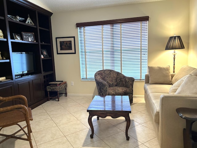 living room with a textured ceiling, a healthy amount of sunlight, and light tile patterned floors