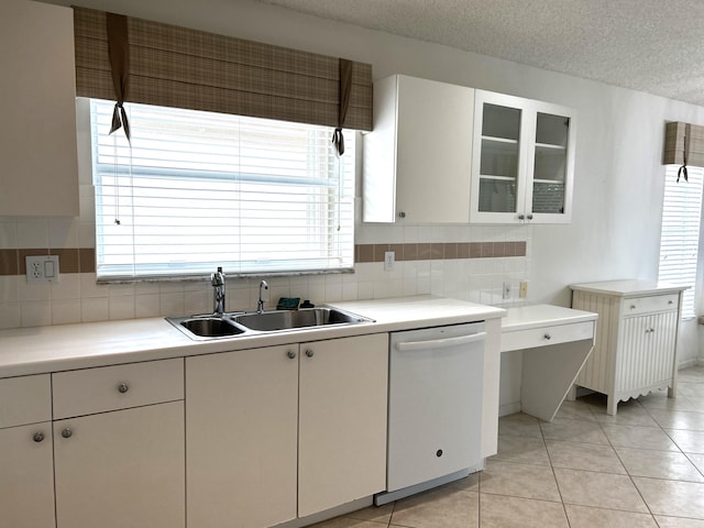 kitchen featuring white dishwasher, white cabinets, a textured ceiling, and a wealth of natural light