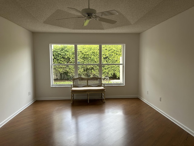 unfurnished room with dark hardwood / wood-style flooring, a textured ceiling, ceiling fan, and a wealth of natural light