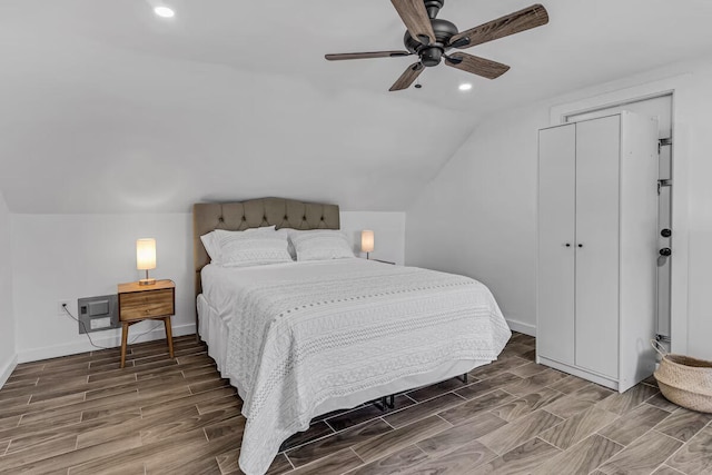 bedroom with lofted ceiling, wood finish floors, recessed lighting, and baseboards