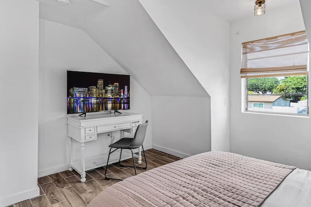 bedroom featuring vaulted ceiling, wood finished floors, and baseboards