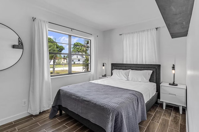 bedroom featuring baseboards and wood tiled floor