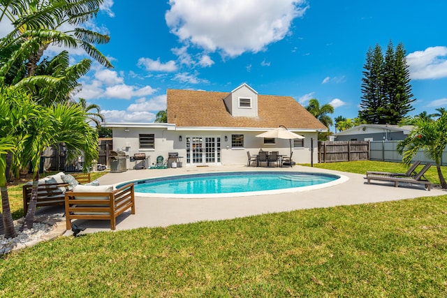 view of pool with a fenced in pool, a patio, french doors, fence, and a yard